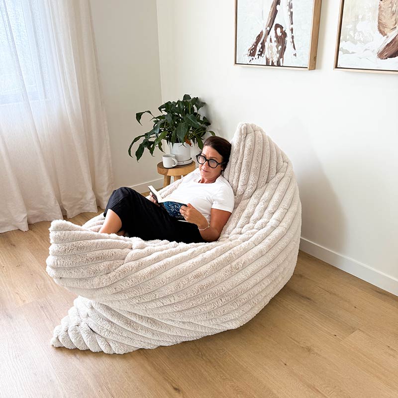 Oversized champagne Cloud Bean Bag mat with woman relaxing and reading indoors