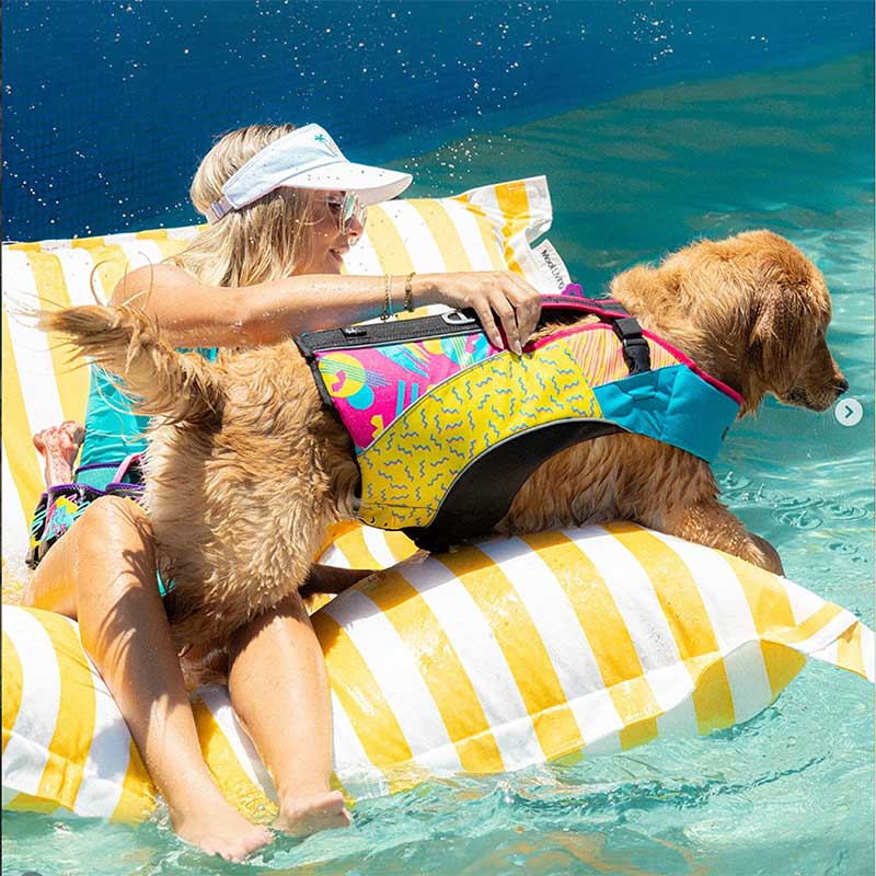 Customer pic of the Santorini Pool Floating outdoor bean bag by Mooi Living in Yellow Stripe with a woman and a dog enjoying floating in the pool.