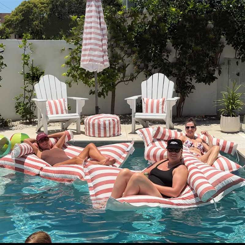 Customer pic of the Santorini Pool Floats outdoor bean bag by Mooi Living in Blush Stripe with people lounging on the pool floats, soaking up the sun, and enjoying the summer days.