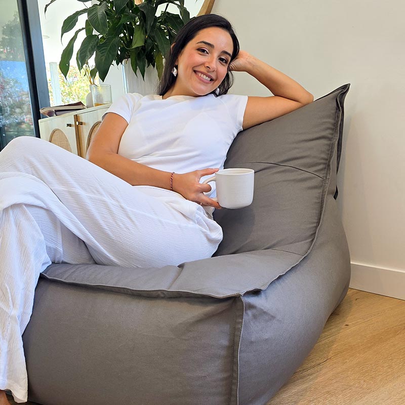 Woman seated on the Mooi Living Single Boss Bean Bag in Mocha 100% cotton canvas within a modern Australian living room.