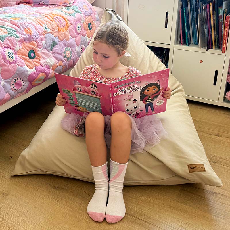 100% Cotton Canvas Mini Triangles in Natural by Mooi Living with young girl sitting and reading a book.