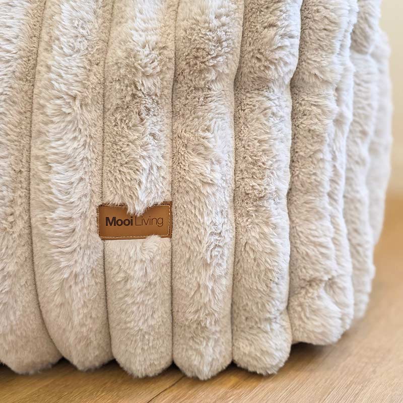 Close-up of the Brooklyn Luxe Lounger Foam Filled Bean Bag in Corduroy Faux Fur indoor bean bag by Mooi Living, showing fabric texture and logo detail.