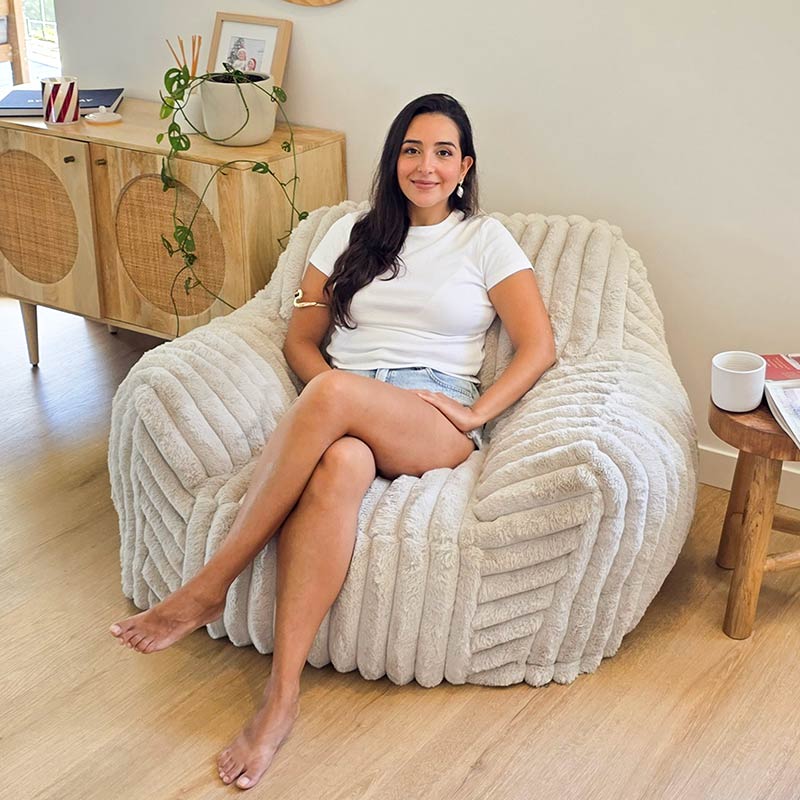 Callie Corduroy Faux Fur Armchair  Foam Filled bean bag indoor Bean Bag by Mooi Living. in a neutral living room, woman seated.