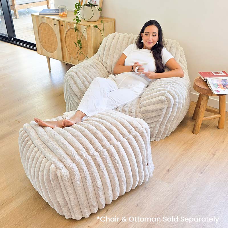 Callie Corduroy Faux Fur Armchair Foam Filled Bean Bag by Mooi Living with matching ottoman in a living room setting. Ottoman sold separately.
