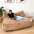 Mooi Double Seater Corduroy Bean Bag Lounger in Caramel indoor bean bag by Mooi Living, woman reclining and reading in a living room.