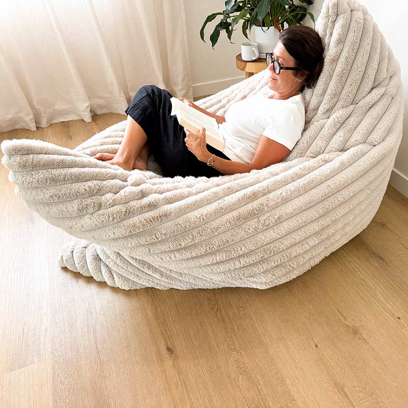 The Cloud Bean Bag indoor bean bag by Mooi Living in Champagne with female model reading a book in a modern living room