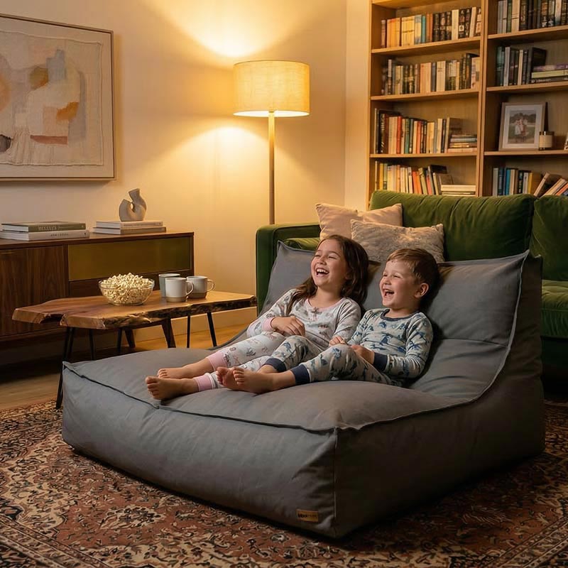 Two young children lounging on a Double Boss Bean Bag Lounger laughing at a movie.