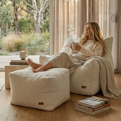 Lady relaxing with a hot coffee on our Natural Serena Armchair bean bag and ottoman, indoor Bean Bag by Mooi Living.