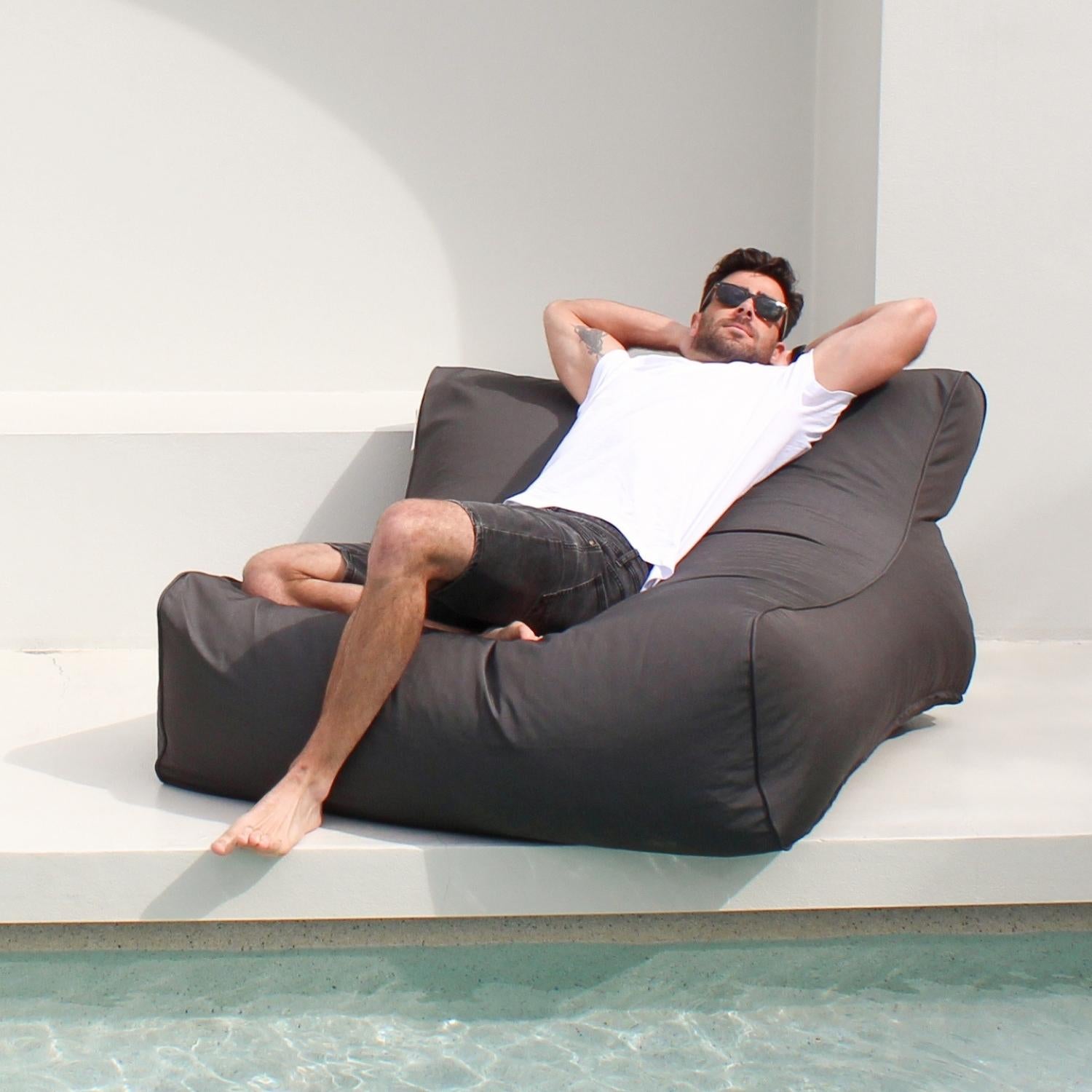 Man sitting in a Oyster Black Double Seater Outdoor Bean Bag Chair - Chilll UV by Mooi Living, MOCHUVBB-OYSBLA