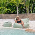 A woman in a black swimsuit and straw hat relaxes on a Sage Green Chill UV outdoor bean bag chair by Mooi Living,  MOCHUVBB-SAGGRE.