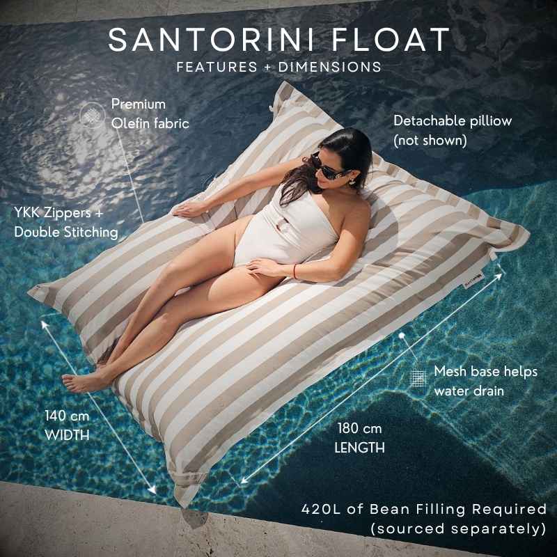 A woman reclines on a Santorini Float in Taupe Stripe in a swimming pool, with overlaid text reading callouts including dimensions, fabric, and mesh drainage.