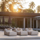 Three Taupe Stripe Cojelo Suave Sunloungers by Mooi Living placed side by side poolside at Villa Essenz Natai, customer photo by @Villa_essenza_natai.