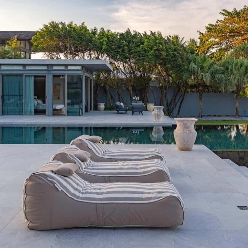 Three Taupe Stripe Cojelo Suave Sunloungers by Mooi Living placed side by side poolside at Villa Essenz Natai, customer photo by @Villa_essenza_natai.