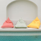 Mooi Living reversible triangle outdoor bean bags in blush, sage green stripe and yellow displayed together beside a pool, MOREVSTRIBB-YEL