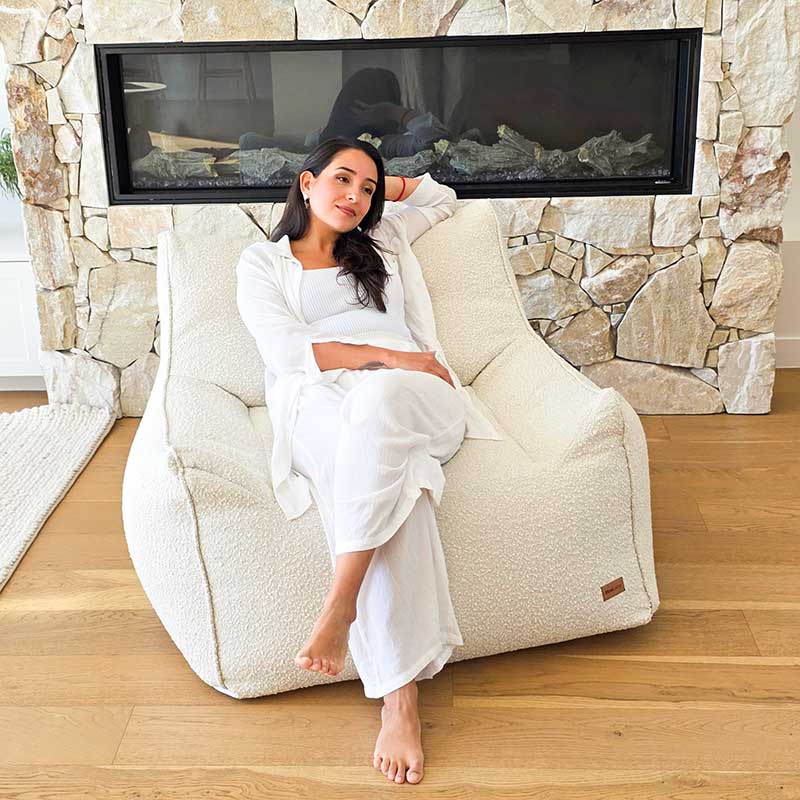 Cream Bouclé Serena Armchair Bean Bag by Mooi Living in a light-filled living room, woman seated.
