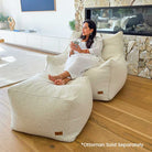 Cream Bouclé Serena Armchair Bean Bag with coordinating ottoman by Mooi Living styled in a modern interior.