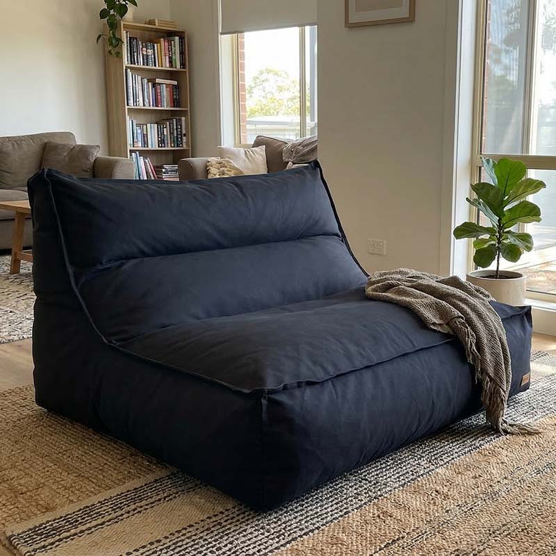 Photo shared by a customer. Cotton Double Boss indoor bean bag by Mooi Living.in Black, in a living room with a bookshelf and plants.