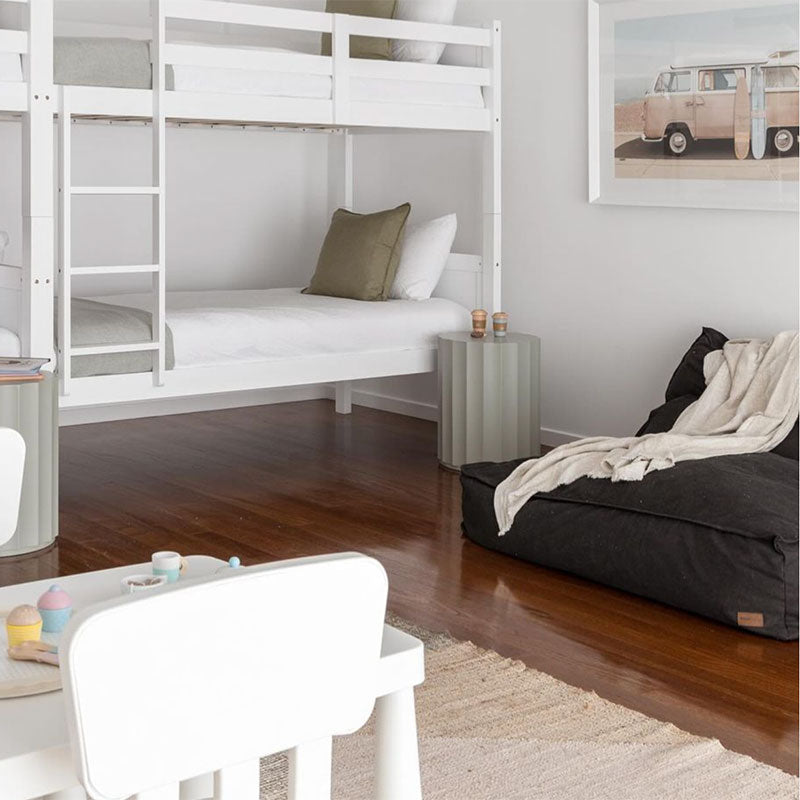 Photo shared by a customer. Cotton Boss Bean Bag Chair in Black in a kids room next to a bunk bed. Perfect reading corner for little humans.