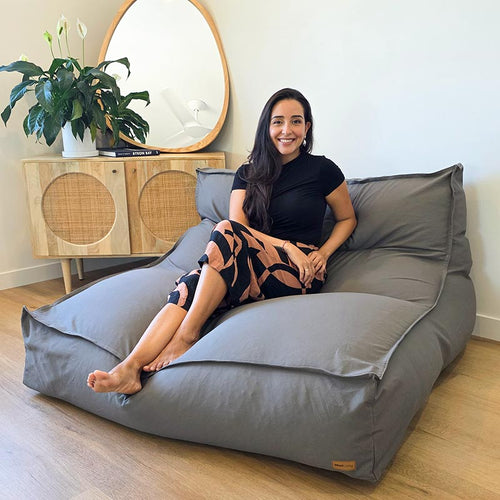 Woman seated on the Mocha Double Boss large bean bag by Mooi Living in a contemporary indoor setting.