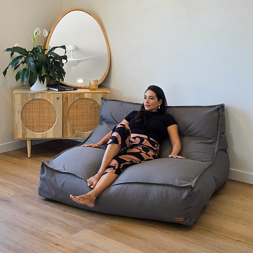 Oversized Mocha Double Boss indoor bean bag by Mooi Living with structured back support and removable cover, woman seated.