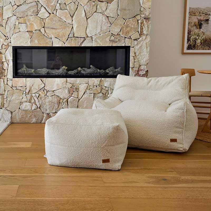 Cream bouclé Serena Armchair and ottoman set by Mooi Living featuring textured fabric.