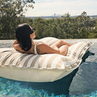 Taupe Stripe Santorini outdoor bean bag pool float outdoor bean bag by Mooi Living supporting model as she floats in a modern swimming pool.