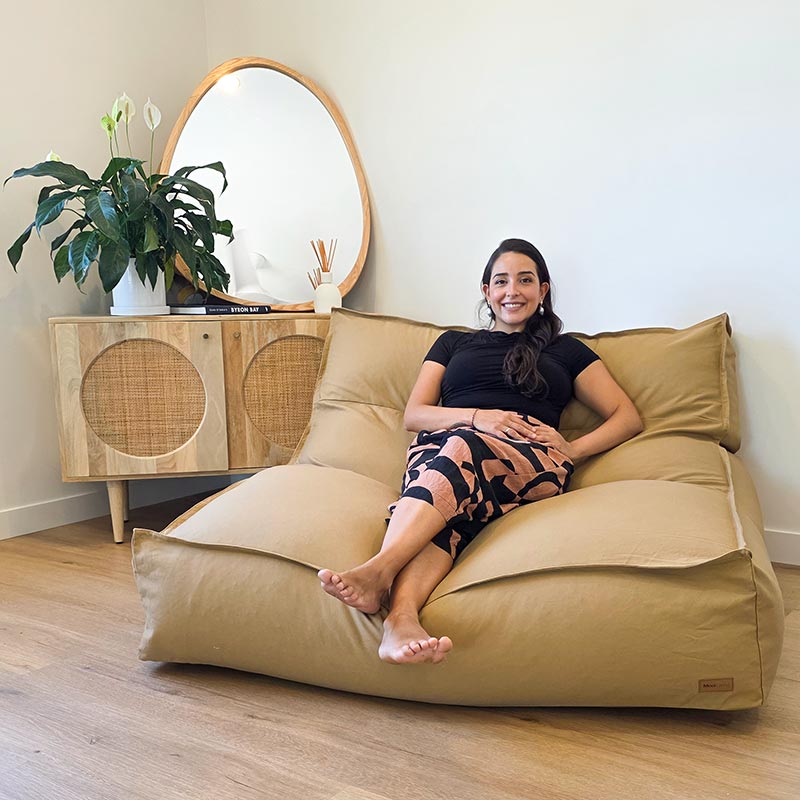 Tan Cotton Double Boss double seater bean bag chair indoor Bean Bag by Mooi Living. in a light-filled living room, a woman seated.