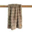 Taupe faux fur throw blanket on a wooden pole