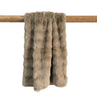 Taupe faux fur throw blanket on a wooden pole